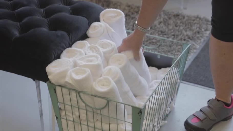 A basket of rolled white towels set out for class